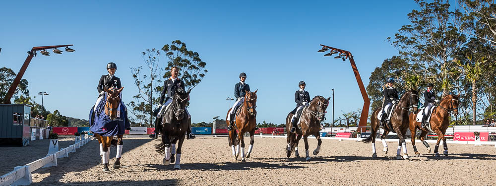Six people riding horses in the outdoor arena Six people riding horses in the outdoor arena